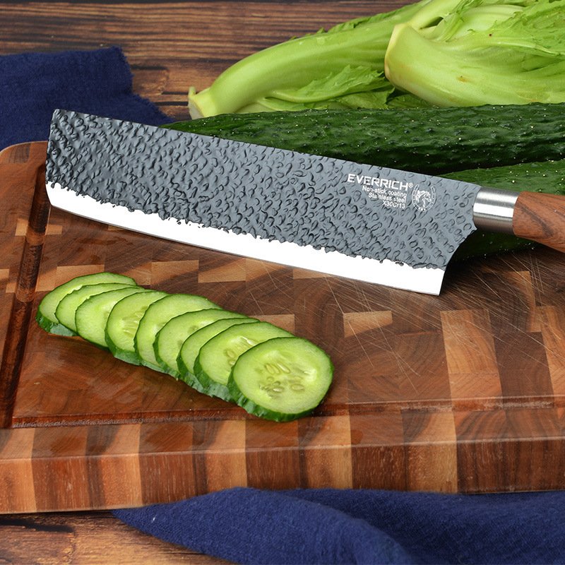 Chef slicing cucumber with hammered stainless steel knife